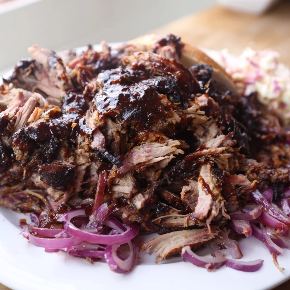 A close-up of a Fire-Kissed BBQ Pulled Pork Sandwich, showing crispy edges and juicy texture.