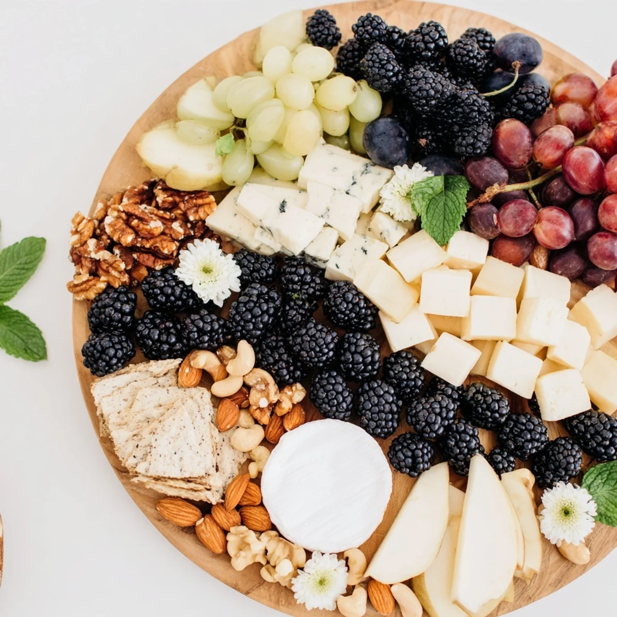The Yin-Yang cheese board, featuring light and dark elements with fresh fruit, offers a unique appetizer.