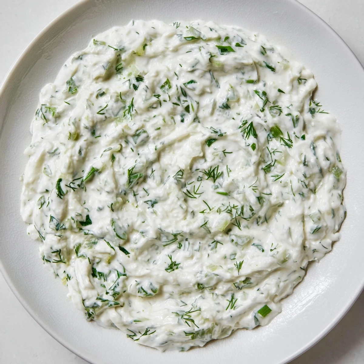 Creamy Greek Yogurt Ranch Dip, garnished with fresh herbs, is ready for your favorite crudités.