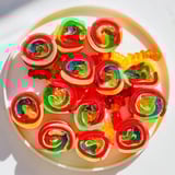 Gummy candies gleam inside the rolled up Rainbow Candy Roll Ups, ready to enjoy as a sweet treat.