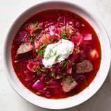 A close-up shot of rich Ukrainian borscht, showcasing the deep red color and savory broth perfectly.