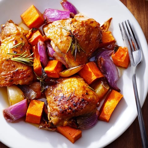 Close-up of honey-glazed chicken with roasted root vegetables, fragrant herbs, and caramelized edges.