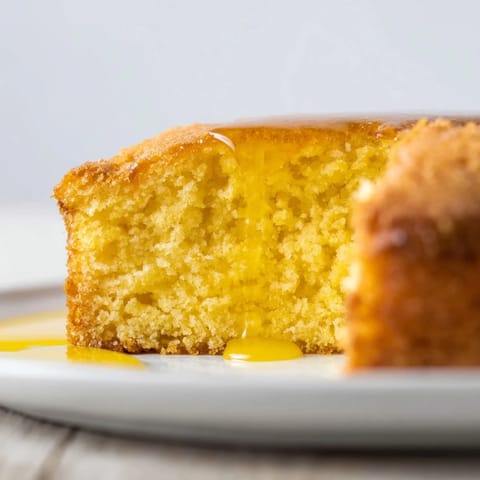 A warm slice of golden honey pound cake, showcasing its moist, delicate crumb perfectly.