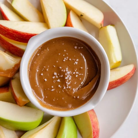 A close-up of sweet Apple Slices with Caramel Dip showing the rich, glistening caramel ready to serve.