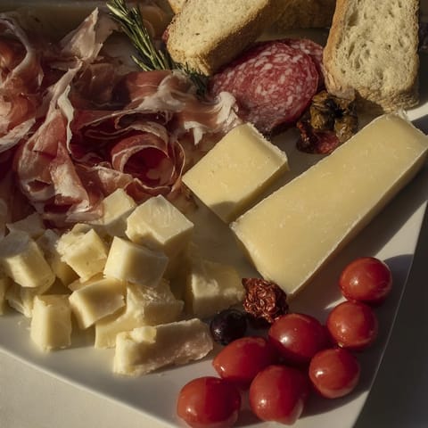 A close-up of a Rustic Italian Farmhouse Board with glistening prosciutto and fresh rosemary sprigs.