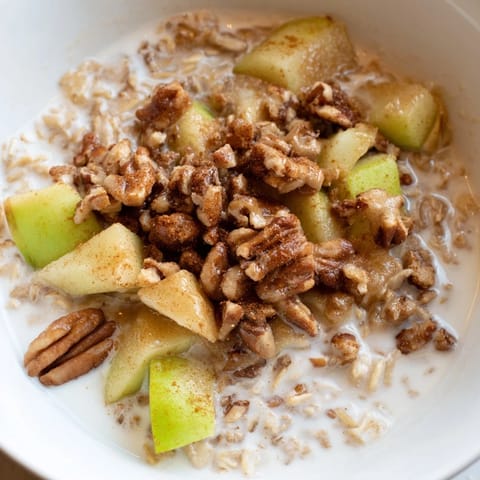 Creamy apple pie oatmeal with oats, topped with caramelized apples and crunchy pecans, a perfect breakfast.