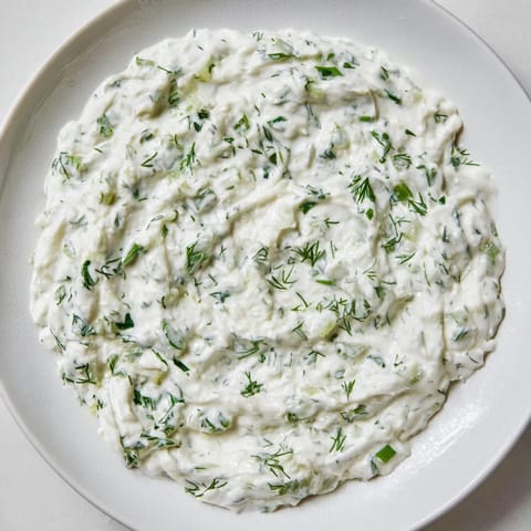Creamy Greek Yogurt Ranch Dip, garnished with fresh herbs, is ready for your favorite crudités.