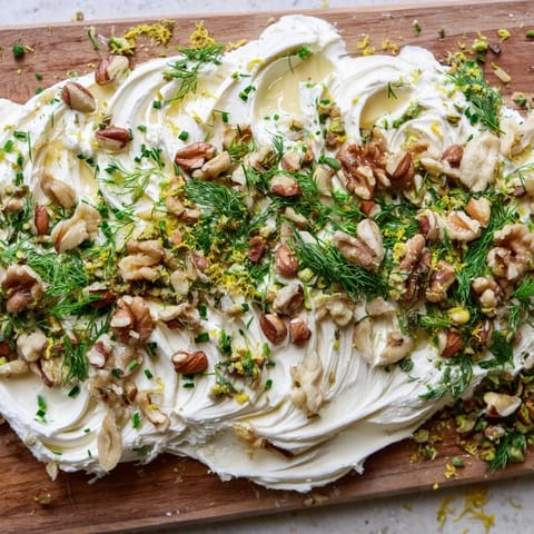 Golden toasted nuts and vibrant herbs adorn this elegant Butter Board Charcuterie appetizer.