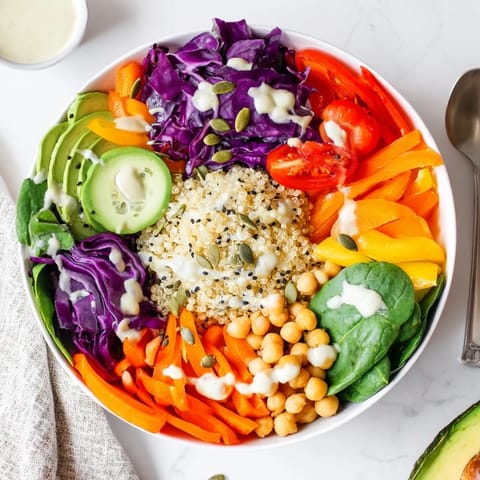 This vibrant Rainbow Buddha Bowl With Quinoa features fluffy grains, crisp veggies, and creamy avocado drizzled with tahini.