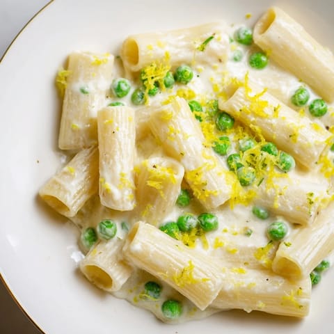 Bright lemon zest and rich ricotta coat al dente peas in a vibrant bowl of pea and lemon ricotta pasta.  