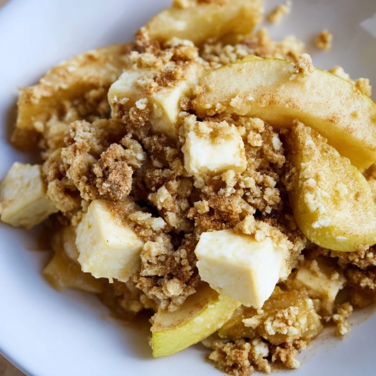 Imagine the delightful aroma of this warm Rustic Apple and Cinnamon Crumble, served with creamy vanilla ice cream.