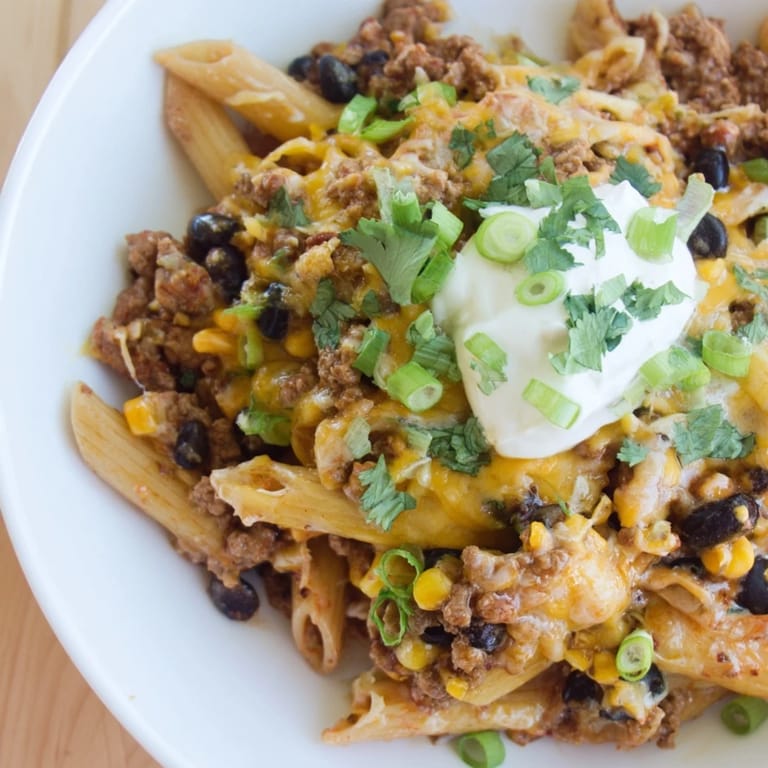 Savor the flavors: warm, comforting bowl of cheesy taco pasta, perfect for dinner tonight.