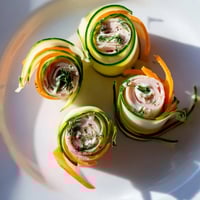 Delectable Ribbon Dancer appetizer, vibrant carrot and cucumber ribbons hug savory smoked turkey.