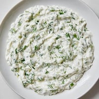 Creamy Greek Yogurt Ranch Dip, garnished with fresh herbs, is ready for your favorite crudités.