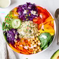 This vibrant Rainbow Buddha Bowl With Quinoa features fluffy grains, crisp veggies, and creamy avocado drizzled with tahini.
