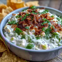 Creamy elote dip with charred corn, cotija cheese, and lime, served with crispy tortilla chips.